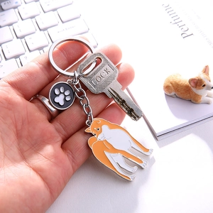 Porte-clés chien Akita en alliage de zinc avec breloque patte sur un bureau