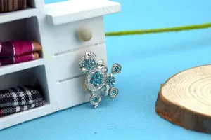 Macro shot of silver poodle pendant encrusted with light blue rhinestones for pet collars