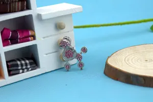 Detailed macro view of silver poodle pet pendant with sparkling pink rhinestones inlay