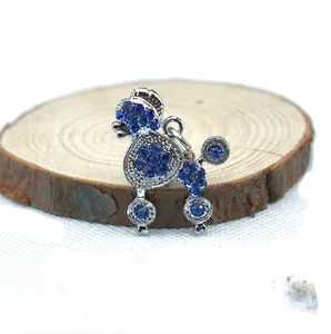 Sparkly blue rhinestone poodle pendant on a natural wooden slice with silver finish