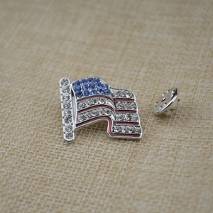 Close-up of USA flag brooch with blue crystals and silver-tone butterfly clutch back