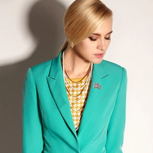 Detailed view of crystal-encrusted American flag brooch paired with layered necklaces