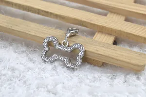 Close-up of a silver bone-shaped pet collar pendant with sparkling pavé crystals