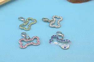 Detailed close-up of bone-shaped pet pendants with colorful rhinestones and lobster clasps