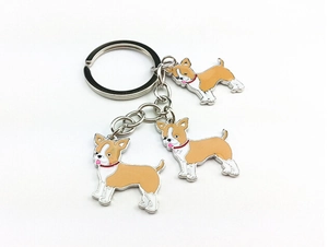 Detail of three Chihuahua dog pendants with red collars on a metal keychain ring
