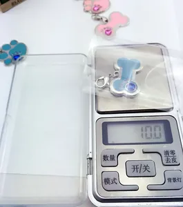 Detail shot of a bone-shaped pet tag with blue enamel and rhinestones weighing 10.0g