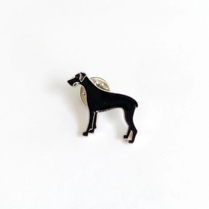 Detailaufnahme einer schwarzen Emaille-Dogge-Brosche mit silberner Metallkontur
