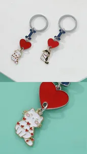 Detail shot of cat enamel keychains with heart charm and silver metal ring