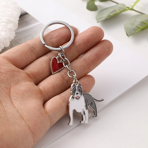 Zinc alloy bulldog keychain with red enamel heart pendant held in hand for detail