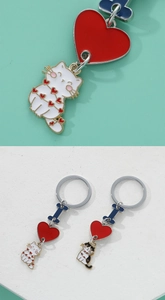 Macro view of enamel cat keychains with red heart charms and colorful bone connectors