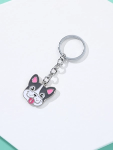 Detailed macro view of a cute French Bulldog enamel keychain with silver chain on a white base