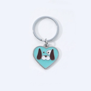 Detail of a mint green heart-shaped keychain featuring a cute cartoon dog on silver ring