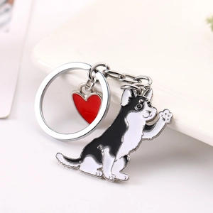 Détail du porte-clés chien mignon avec pendentif cœur rouge sur fond blanc pur