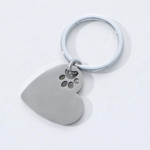 Polished stainless steel heart-shaped keychain with paw print cutout on white background