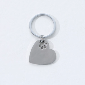 Polished heart-shaped stainless steel keychain featuring a delicate hollow paw print cutout