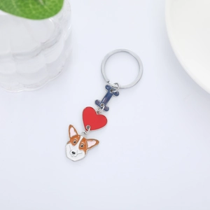 Detail of cartoon Corgi keychain with heart and bone charms on white background