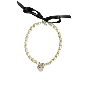 Elegant pet pearl necklace with rhinestone paw pendant and black ribbon bow for small cats