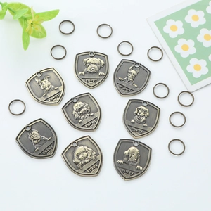 Vintage bronze shield-shaped pet ID tags set with dog patterns and attachment rings