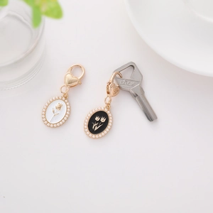 Close-up of vintage oval floral charms with gold rose and tulip motifs and pearl trim