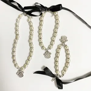 Elegant pearl pet necklace set with rhinestone paw pendants and black satin bows