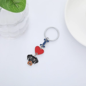 Close-up of metal enamel keychain with blue bone, red heart, and dog head charms