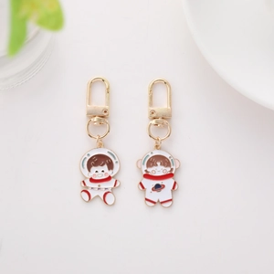 Detail of cartoon astronaut metal keychains with rose and star enamel ornaments