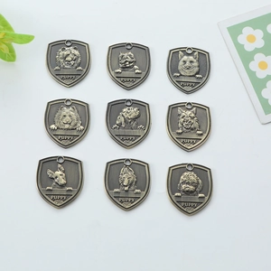 Set of nine shield-shaped antique bronze dog tags with various engraved puppy head designs
