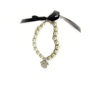White faux pearl pet necklace with rhinestone paw pendant and black ribbon bow detail