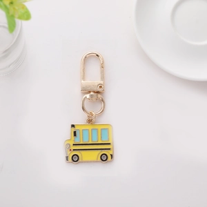 Porte-clés créatif en métal bus scolaire jaune avec fermoir sur fond blanc épuré