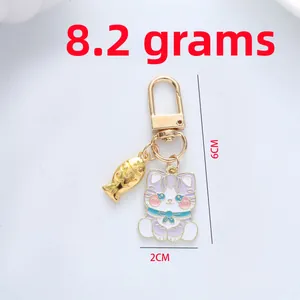 Detailed view of enamel cat keychain with gold fish charm and size measurements