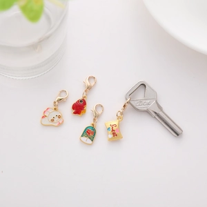 Detail of four enamel cartoon charms including roses and astronauts with golden clasps