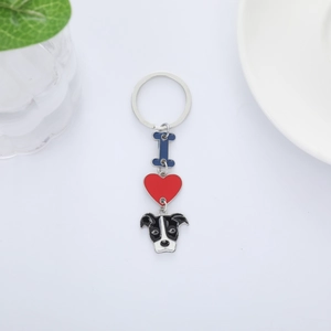Detail of a cartoon dog keychain with blue letter I and red heart on white background