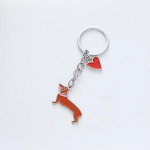 Detail of dachshund dog pendant and red heart charm on silver metal keychain