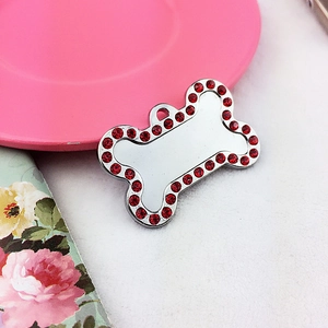 Detailed macro view of bone shaped pet tag with red rhinestones and engraving space