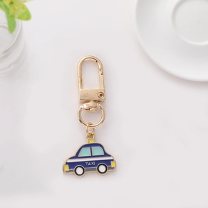 Détail d'un porte-clés taxi bleu créatif avec fermoir doré sur une surface blanche épurée