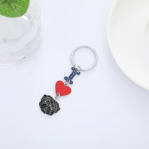 Close-up of black Pug dog pendant with red heart and blue bone on metal keychain