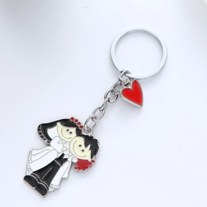 Detail of cartoon bride and groom metal keychain with a red heart charm for weddings