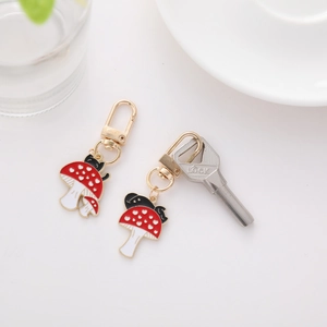 Close-up of alloy mushroom keychains with heart patterns and golden lobster clasp