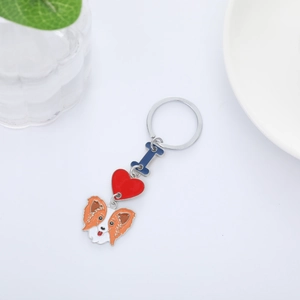 Detailed view of dog keychain with blue letter I and red heart on white surface