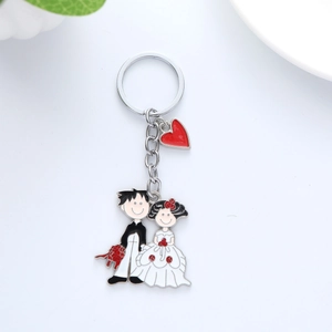 Détail du porte-clés de mariage en métal avec mariés et breloque cœur rouge pour sac