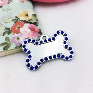 Detail view of bone-shaped pet tag with shiny silver finish and blue rhinestones
