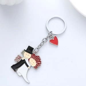 Détail d'un porte-clés couple de mariés en métal avec petit cœur rouge pour mariage