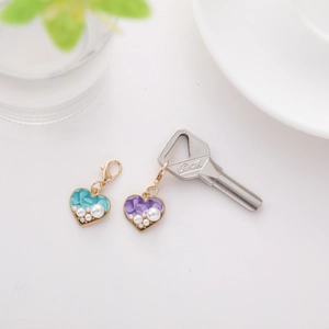 Close-up of heart-shaped blue and purple charms with faux pearls and golden clasps