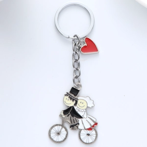 Détail du porte-clés argenté avec couple de mariés à vélo et pendentif cœur rouge