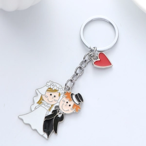 Detail of cartoon wedding couple keychain with heart pendant on polished metal ring