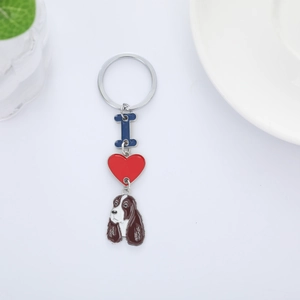 Cute cartoon dog keychain with blue bone and red heart charm on white background