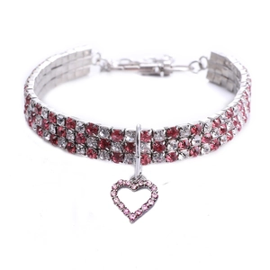 Detail von rot-weißem Strass-Haustierhalsband mit funkelndem Herzanhänger aus Metall
