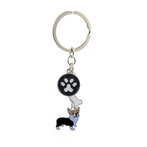 Detail showing a metal corgi keychain with paw print and bone pendants on white background