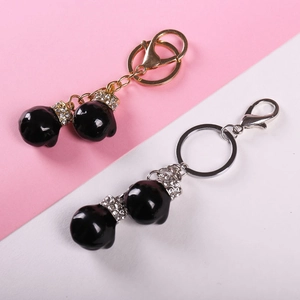 Creative boxing glove keychains with black glossy finish and sparkling rhinestones in gold and silver