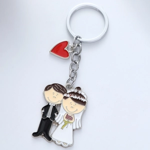 Cartoon metal bride and groom keychain set with red heart pendant on white background